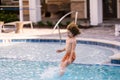 Kid jumping in swim pool. Kid enjoying summer holiday, swiming in pool. Kid having fun on summer holidays at pool. Happy Royalty Free Stock Photo