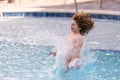 Kid jumping in swim pool. Kid splashing in summer water pool. Kid splash in swim pool. Excited happy little boy jumping Royalty Free Stock Photo