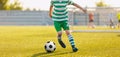 Kid kicking soccer ball. Close up action of boy soccer player running after ball