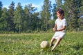 Kid kicking a soccer ball on the field Royalty Free Stock Photo