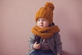 Kid in knitted mustard color hat