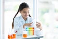 Kid in lab coat learning chemistry in school laboratory, Kid scientist studying science, experimenting with chemicals, Young