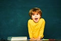 Kid is learning in class on background of blackboard. Happy school kids. Talented child. School and education concept. Royalty Free Stock Photo