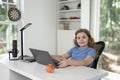 Kid learning at home with laptop and books. Child learn online using laptop at desk. Learning with homework in child room. E Royalty Free Stock Photo