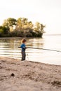 Kid learning how to fish, holding a fishing rod on a lake, baby pulling rod while fishing on weekend, children on nature Royalty Free Stock Photo