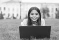 kid learning private lesson. blogging. happy girl sitting on green grass with laptop. Start up. child playing computer Royalty Free Stock Photo