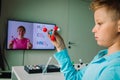Kid learning remotely. Boy making experiments during online chemistry lesson at home Royalty Free Stock Photo