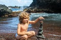 Kid learning sort or stack pebble stone tower or pyramid on water for balance, training and meditation with nature, kids Royalty Free Stock Photo