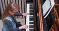 Kid learning to play piano at home.Kid practicing piano.Side view.Little girl playing piano Royalty Free Stock Photo