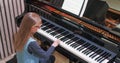 Kid learning to play piano at home.Kid practicing piano.Side view.Little girl playing piano Royalty Free Stock Photo