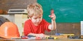 Kid learning to use screwdriver. Concentrated kid working in repairs workshop. Future occupation concept