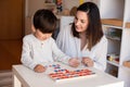 Kid learning to write and read with a alphabet and mother or teacher help. Homeshooling. Learning Community. Montessori School