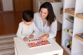 Kid learning to write and read with a alphabet and mother or teacher help. Homeshooling. Learning Community. Montessori School