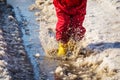 Kid legs in rainboots jumping in the ice puddle Royalty Free Stock Photo