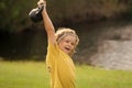 Kid lifting the kettlebell in park outside. Kid boy working out with dumbbells. Sport and kids training. Royalty Free Stock Photo