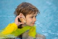 Kid listening to the ocean in a shell. Little boy holding a seashell close to his ear. Child play with shell at the Royalty Free Stock Photo