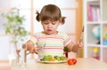 Kid little girl eats vegetarian food at home