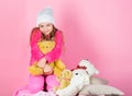 Kid little girl play with soft toy teddy bear pink background. Teddy bears improve psychological wellbeing. Unique