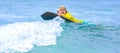 Kid little surfer learn to ride on surfboard on sea waves. Kids outdoor water sport, swimming activity in surf camp Royalty Free Stock Photo