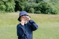 Kid looking through mini microscope with wondering face, Excited Child on a camping school trip in green forest, Kid explorer with Royalty Free Stock Photo