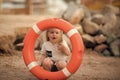 Kid looking through orange life ring at beach. Royalty Free Stock Photo