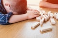 Kid lost the jenga game. His tower from wooden blocks had fallen. Concept of risk and strategy in business and construction. Royalty Free Stock Photo