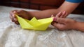 A kid making paper boat at home