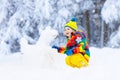 Child making snowman. Kids play in snow in winter Royalty Free Stock Photo