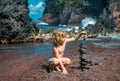 Kid making stack stones on the coast of the sea in the nature. Cairn on the ocean beach, five pebbles tower. Concept of Royalty Free Stock Photo