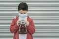 Kid with medical mask take photos with its camera Royalty Free Stock Photo