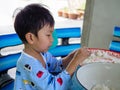 Kid molding white dough with happy face. Asian cute child boy cooking Thai dessert.