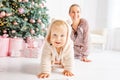 Kid and mother near new-year tree