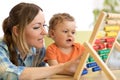 Kid and mother playing with abacus at home Royalty Free Stock Photo