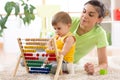 Kid and mother playing with abacus at home Royalty Free Stock Photo