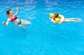 Kid and mother in water at sea beach. Little girl floating in pool with inflatable ring. Child at swimming lesson with mom Royalty Free Stock Photo