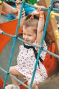 Kid on obstacle course. Pretty happy young girl playing outside in playground. Portrait Of Cute Girl Playing At Royalty Free Stock Photo