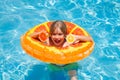 Kid with orange in the pool. Summer fruits. Child having fun in summertime. Summer holidays and vacation with kids Royalty Free Stock Photo