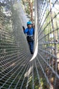 Kid overcoming mesh obstacle in rope park Royalty Free Stock Photo