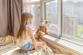 Kid with painted rainbow during Covid-19 quarantine at home. Caucasian Girl with teddy bear toy near window. Stay at home Social Royalty Free Stock Photo