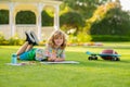 Kid painter draw on playground. Child artist paints creativity vacation. Kid boy draws in park laying in grass having Royalty Free Stock Photo