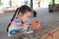 Kid painting, Portrait little child girl intend to paint on earthenware dish