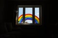 Kid painting rainbow during Covid-19 quarantine at home. Girl near window. Stay at home Social media campaign for