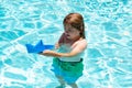 Kid with paper boat in sea water on summer vacation. Little boy playing with toy paper boat on sea. Summer vacation, kid Royalty Free Stock Photo