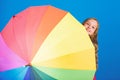 Kid peek out colorful rainbow umbrella. Color your life. Girl cheerful hide behind umbrella. Colorful umbrella accessory