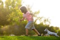 Kid with pets puppy running. Happy Child and pet dog runs at backyard lawn. Royalty Free Stock Photo