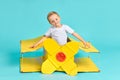 Kid pilot is flying on yellow cardboard airplane Royalty Free Stock Photo