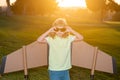 Kid with pilot glasses traveller with backpack wings. Child playing pilot aviator and dreams outdoors in park. Royalty Free Stock Photo