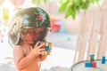 Kid with a pilot`s helmet playing with a rubik`s cube with the background out of focus Royalty Free Stock Photo