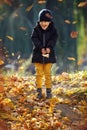 Kid play in autumn park. Child throwing yellow leaves. Child boy with oak and maple leaf. Fall foliage. Family outdoor fun in Royalty Free Stock Photo