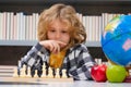 Kid play chess at school. Chess for intelligent kid. Child genius, smart pupil playing logic board game. Clever school Royalty Free Stock Photo